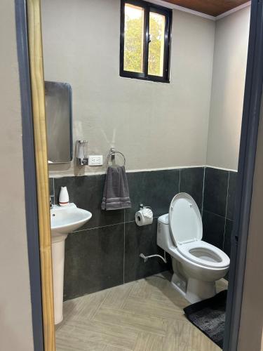 a bathroom with a toilet and a sink at Boaco Suites - Apartments in Boaco