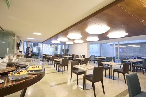 a dining room with tables and chairs in a restaurant at Hotel bh Bicentenario in Bogotá