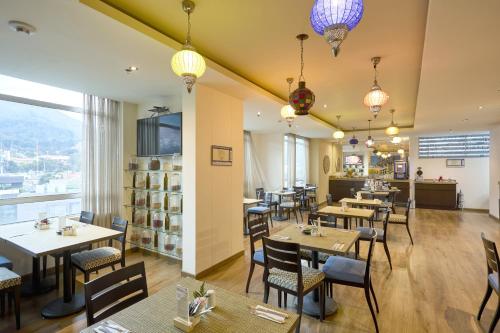 a restaurant with tables and chairs with a view at Hotel bh Usaquén in Bogotá