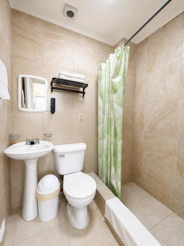 a bathroom with a toilet and a sink and a shower at Suitesecu Rentals Cuenca in Cuenca