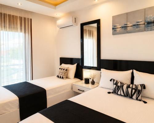 a bedroom with two beds and a mirror at Chrisella Crystal in Skala Rachoniou
