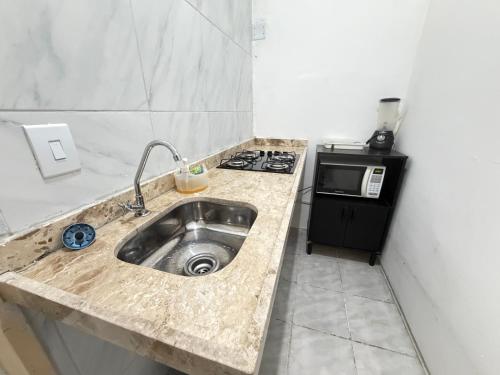a kitchen counter with a sink and a stove at ap 2 quartos com ar e garagem bairro derby in Sobral