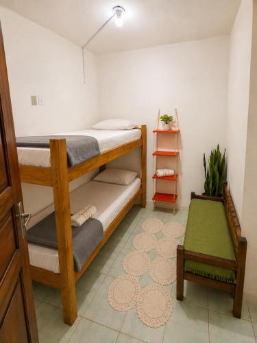 a room with two bunk beds and a table at Ammonite Hostel - Itacaré in Itacaré