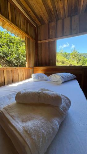 a bedroom with a large bed with a large window at Recanto Salto Ano Bom in Corupá