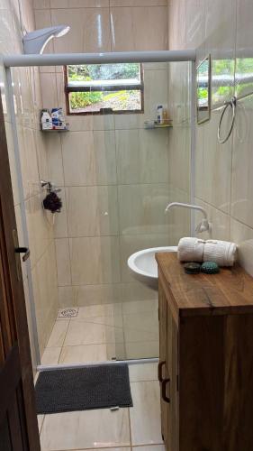 a bathroom with a shower and a sink at Recanto Salto Ano Bom in Corupá