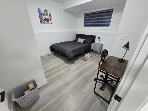 a bedroom with a bed and a desk in a room at The Vilaskan in Saskatoon