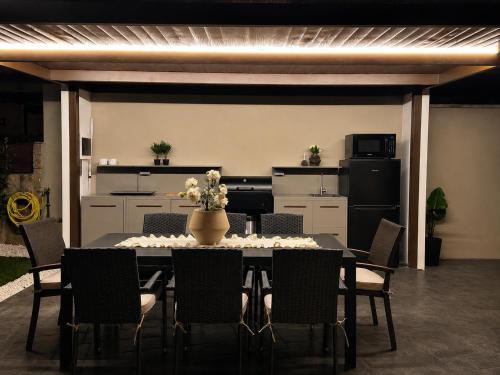a dining room table with chairs and a kitchen at Casa A LAXE in Vilagarcia de Arousa