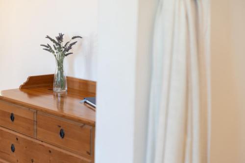 a vase of flowers sitting on top of a dresser at Villa Katerina BBQ & pool! in Metaxáta