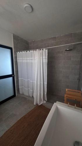 a bathroom with a tub and a shower curtain at LA SIESTA Suites in Huarmey