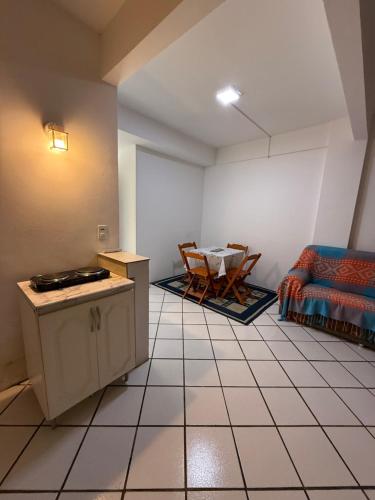 a living room with a table and a couch at KITNETS Kretzer Hinckel 2 - CENTRO in Alfredo Wagner