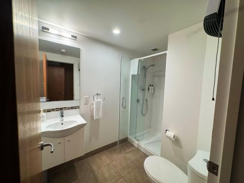 a bathroom with a sink and a shower and a toilet at Focus Motel in Christchurch