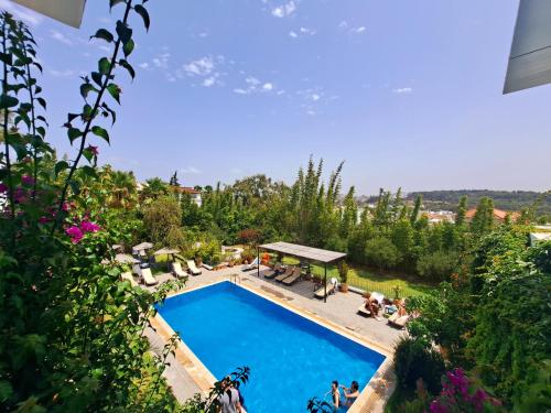 an overhead view of a swimming pool with people sitting around it at Studio Appartement Perdicaris en rez de jardin - maison dhotes Dar Tanja in Tangier