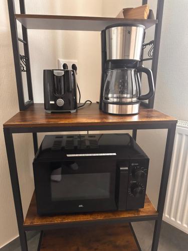 a microwave and a blender on a shelf at Ferienwohnung EG in Gräfenhainichen