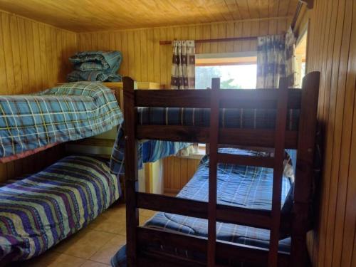 a room with two bunk beds and a window at Tu Refugio Natural en Mahuida in Pucón
