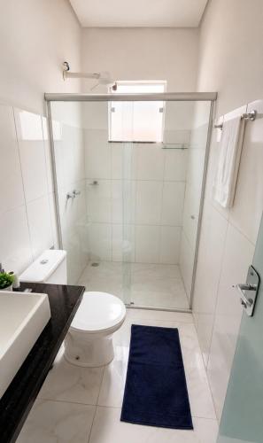 a bathroom with a shower and a toilet and a sink at Pousada Jeitim Mineiro in Capitólio
