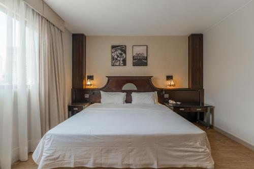 a bedroom with a large white bed with two night stands at Batel Luxury - Próx Pátio Batel in Curitiba