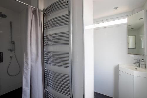 a bathroom with a shower curtain and a sink at Spacious 5Bedroom Home with Garden & Parking Sleeps 11 Near Elizabeth Line in Goodmayes