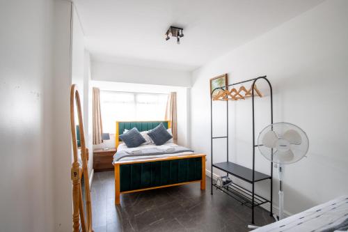 a small bedroom with a bed and a window at Spacious 5Bedroom Home with Garden & Parking Sleeps 11 Near Elizabeth Line in Goodmayes