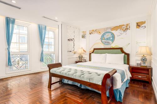 a bedroom with a large bed and two windows at Hanoi Maro Hotel in Hanoi