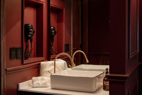 a bathroom with a white sink and a mirror at The Urban Muse suite in Mexico City