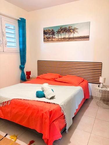 a bedroom with a large bed with red and white sheets at Kessydryss in Sainte-Marie