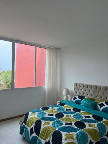 a bedroom with a bed and a large window at puerto real isla de margarita in La Playa