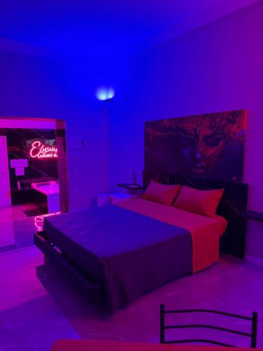 a bedroom with a bed in a purple room at Elysium Luxury Suite in Trabia