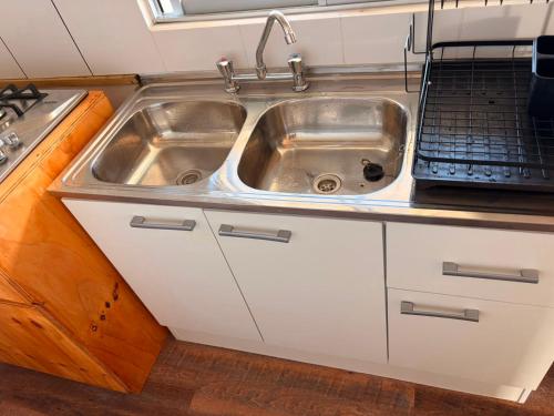a kitchen with a stainless steel sink and a stove at Cabaña Tea Tea 2 in Hanga Roa