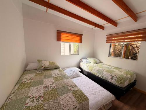 a bedroom with two beds and a window at Cabaña Tea Tea 2 in Hanga Roa