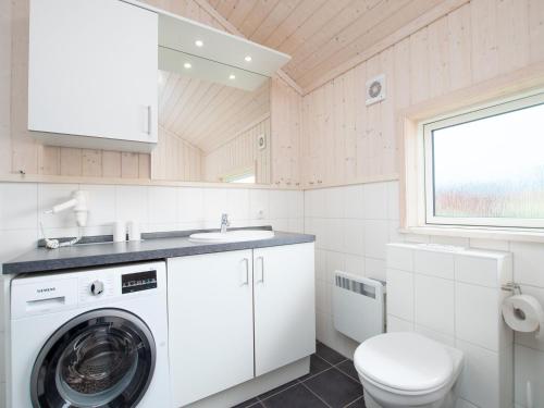 a bathroom with a washing machine and a toilet at Grobenbrode Split-Wing House in Grossenbrode