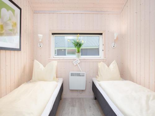 two beds in a small room with a window at Split-Wing House for Eight in Grossenbrode