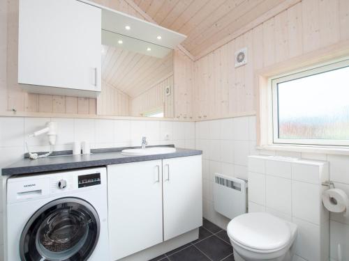 a bathroom with a washing machine and a toilet at Split-Wing House for Eight in Grossenbrode