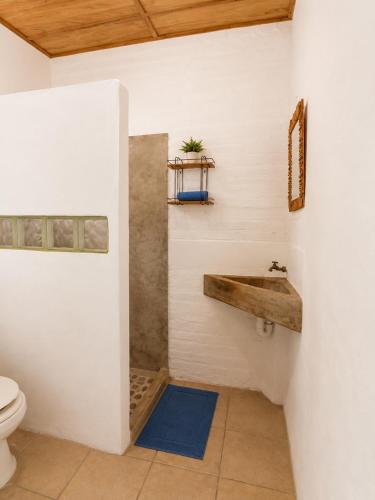 a bathroom with a sink and a toilet at Bananoz Surfhouse in Transito
