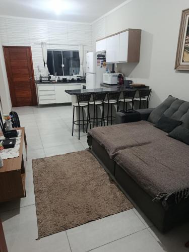 a living room with a couch and a kitchen at Morada do Mazza in Boituva