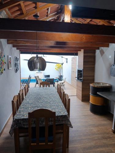 a dining room with a table and chairs and a living room at Morada do Mazza in Boituva