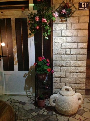 a vase sitting in front of a door with flowers at Apartments Villa Antony in Drvenik