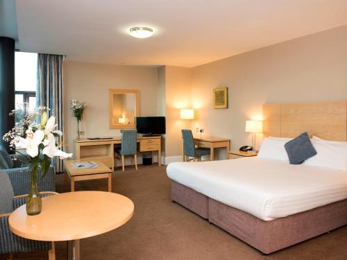 a hotel room with a bed and a desk at Green Isle Hotel, Dublin in Clondalkin 