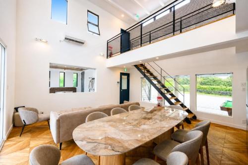 a room with a table and chairs and a staircase at IPC Resort富津竹岡 in Futtsu