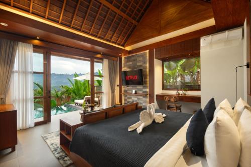 a bedroom with a bed and a view of a pool at Kankhara Villas Sidemen in Sidemen