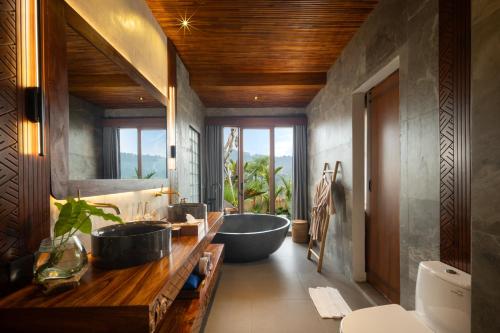 a bathroom with three sinks and a bath tub at Kankhara Villas Sidemen in Sidemen
