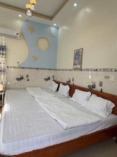a bedroom with a large bed with white sheets at Phú Hiệp Hotel in Thanh Xuân