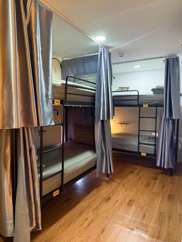 two bunk beds in a room with a wooden floor at Rom Casa Hostel Da Nang in Danang