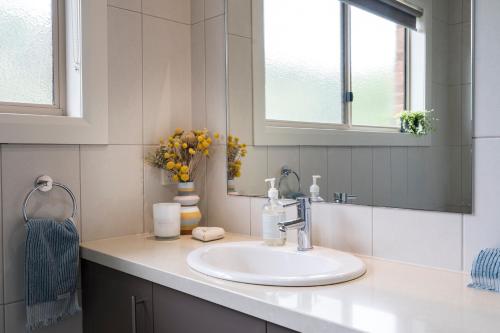 a bathroom with a sink and a mirror at The Cottage-Gather the crew or the family and prepare for fun times and relaxation. Making memories in Yarra Junction