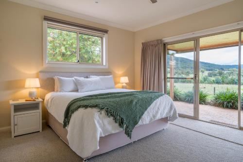 a bedroom with a bed and a large window at The Cottage-Gather the crew or the family and prepare for fun times and relaxation. Making memories in Yarra Junction