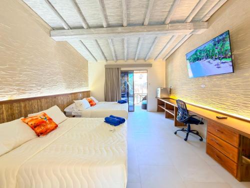 a bedroom with two beds and a desk with a computer at Tritonia Island Tintipán in Tolú