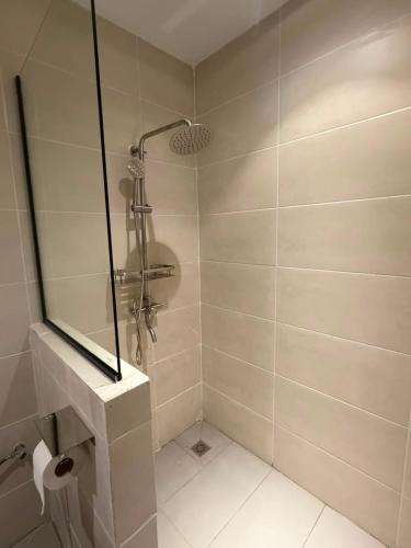 a bathroom with a shower with a mirror at The Velton Inn in Bintulu