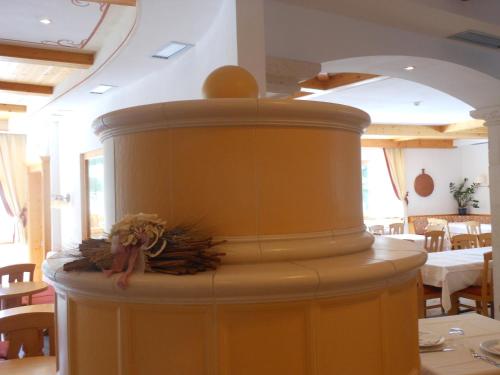 un barril amarillo con flores sobre una mesa en un restaurante en Il Falchetto en Sarnonico
