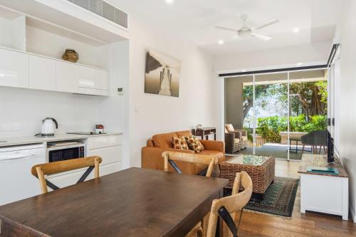 a kitchen and living room with a table and chairs at Reflections Topaz Villa 3 in Picnic Bay