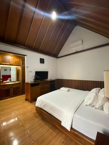 a bedroom with a large white bed and a desk at Villa GHANIA in Labuanbalat
