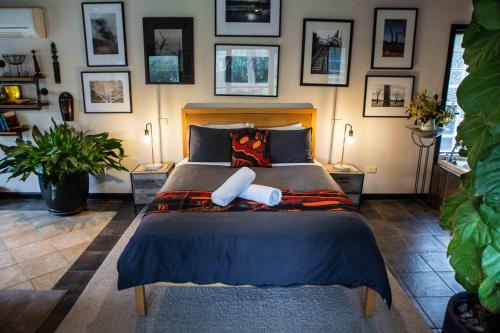 a bedroom with a large bed with pictures on the wall at A Heavenly Escape in Halls Gap